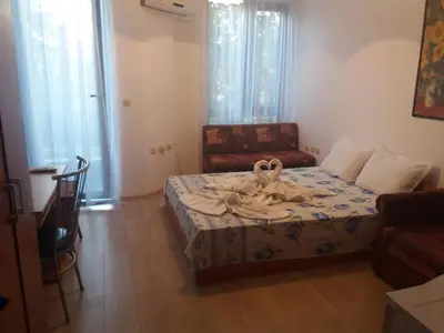 a small room with a bed and a chair at Студио Наде in Tsarevo