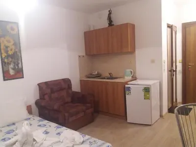 a small kitchen with a chair and a refrigerator at Студио Наде in Tsarevo