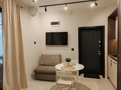 a living room with a table and a chair and a tv at SOHO apartments in Burgas City
