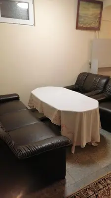 a white table and a leather couch in a room at Апартамент опера in Varna City