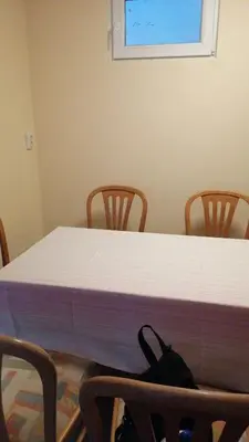 a table with three chairs and a white mattress at Апартамент опера in Varna City