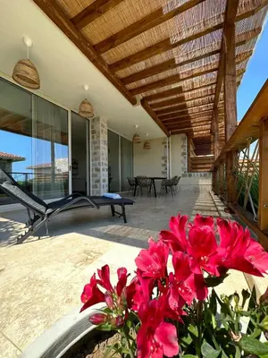 a patio with pink flowers in a vase at Lozenets Luxury Pool Villa by Lozenetsvillas in Lozenets