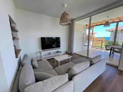 a living room with a couch and a flat screen tv at Lozenets Luxury Pool Villa by Lozenetsvillas in Lozenets