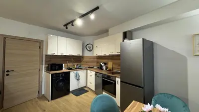 a kitchen with white cabinets and a stainless steel refrigerator at Atelier Pepi in Varna City