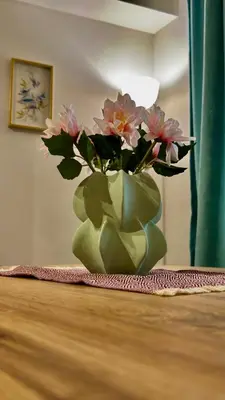 a green vase with flowers sitting on a table at Atelier Pepi in Varna City