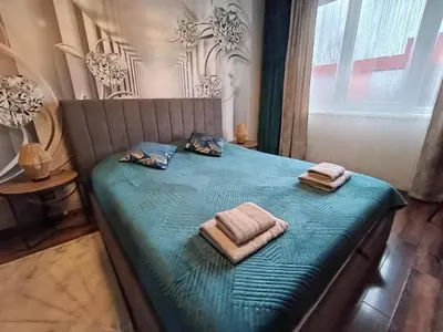 a bed with two towels and two pillows on it at Villa Valencja Apartments Family in Sunny Beach