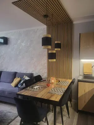 a living room with a table and a blue couch at Villa Valencja Apartments Family in Sunny Beach