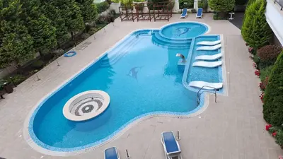 an overhead view of a swimming pool with chairs and a frisbee at Villa Valencja Apartments Family in Sunny Beach