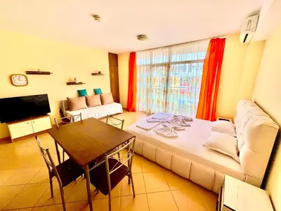 a living room with a couch and a table at Grand Kamelia Holiday Apartments Sunny Beach in Sunny Beach