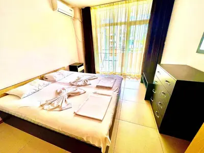 a hotel room with a bed with towels on it at Grand Kamelia Holiday Apartments Sunny Beach in Sunny Beach