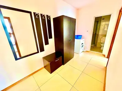 a bathroom with a cabinet and a tiled floor at Grand Kamelia Holiday Apartments Sunny Beach in Sunny Beach