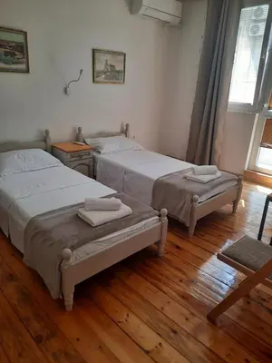 two beds in a room with wooden floors at Guest Rooms Ilko in Varna City