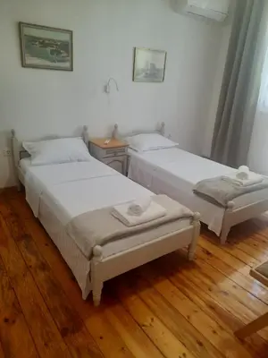 two beds in a room with wooden floors at Guest Rooms Ilko in Varna City