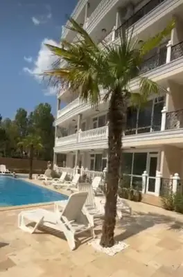 a palm tree in front of a building at Yana Sanny Beach in Sunny Beach