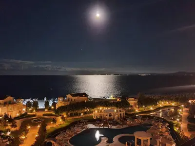 a view of a resort at night with a full moon at Двуспален апартамент Сънсет ризорт с фронтален изглед към море in Pomorie