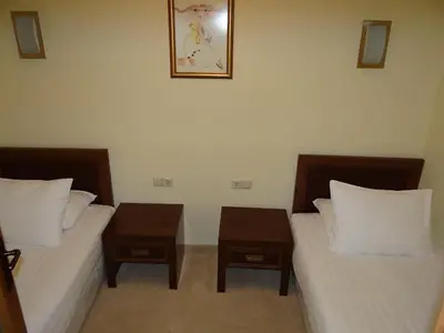 two beds in a room with two night stands at Двуспален апартамент Сънсет ризорт с фронтален изглед към море in Pomorie