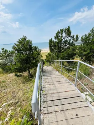 a wooden boardwalk over a hill with trees at Apartment for guests Panorama - first line sea in Burgas City