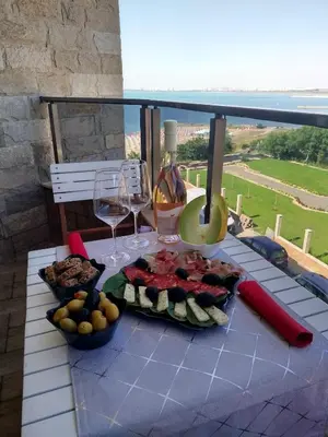 a table with a plate of fruit and wine glasses at Apartment for guests Panorama - first line sea in Burgas City