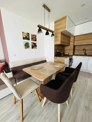 a kitchen and dining room with a wooden table and chairs at Apartment for guests Panorama - first line sea in Burgas City
