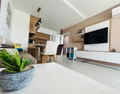 a living room with a table and a tv at Apartment for guests Panorama - first line sea in Burgas City