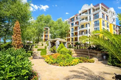 a hotel with a garden in front of a building at Harmony Suites 2 Private Studio 219 in Sunny Beach