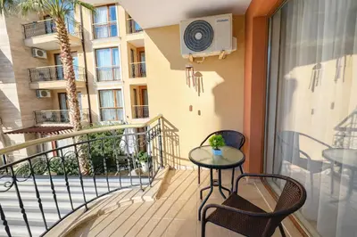 a balcony with a table and chairs and a heater at Harmony Suites 2 Private Studio 219 in Sunny Beach