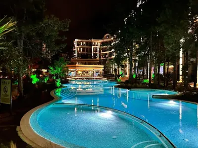 a swimming pool at night with a building in the background at Harmony Grand Resort 16 Private Apartment 214 in Sunny Beach