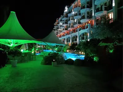 a green tent next to a swimming pool at night at Harmony Grand Resort 16 Private Apartment 214 in Sunny Beach