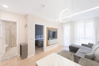 a white living room with a couch and a tv at Harmony Grand Resort 16 Private Apartment 214 in Sunny Beach
