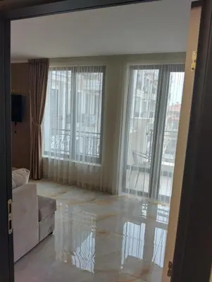 a living room with a couch and large windows at Emperium, Style, Coziness and tranquility by the sea in Sveti Vlas! in Sveti Vlas