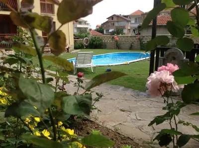 a swimming pool with a chair in a yard at Апартамент Park & Sea Retreat in Obzor