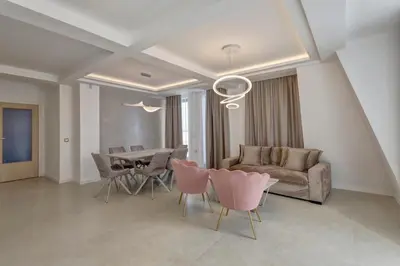 a living room with a couch and a table and chairs at Central Luxury One Bedroom in Varna in Varna City