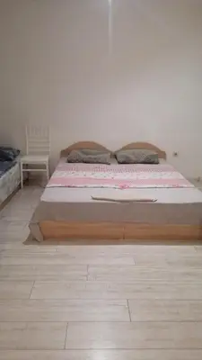 a bed with a wooden frame in a bedroom at Апартамент 27 юли 1 in Varna City