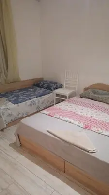 a bedroom with two beds and a chair at Апартамент 27 юли 1 in Varna City