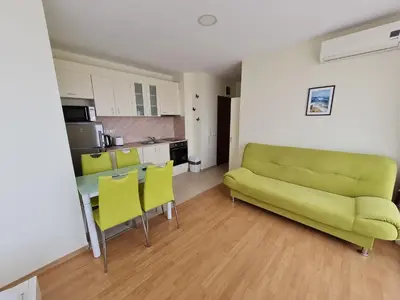 a living room with a couch and a table and chairs at Studio in a Resort with 9 pools in Sunny Beach