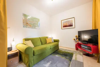a living room with a green couch and a flat screen tv at Calm space in Varna top center in Varna City