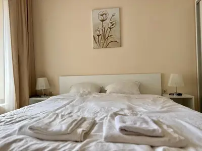 a white bed with towels on top of it at Above the Sea Luxury Apartment in Varna City