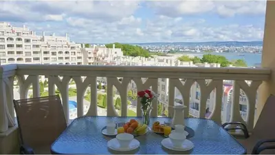 a blue table with a bowl of fruit on a balcony at Above the Sea Luxury Apartment in Varna City