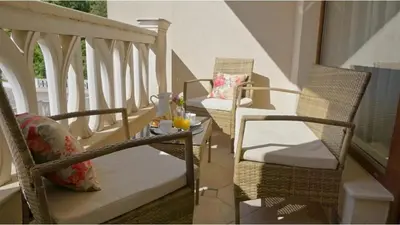 a porch with two chairs and a table with a candle at Above the Sea Luxury Apartment in Varna City