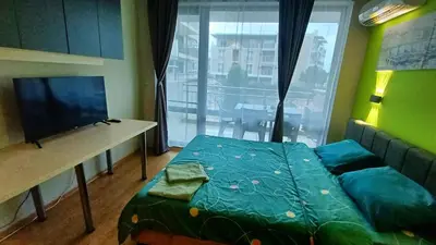 a room with a bed and a table and a window at Complex-Lesso in Ravda