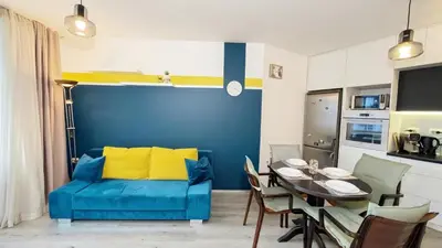 a living room with a blue couch and a table at KJ Apartments - SwimmingPool - 3 Min From the Beach in Burgas City