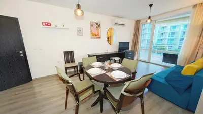 a dining room and living room with a table and chairs at KJ Apartments - SwimmingPool - 3 Min From the Beach in Burgas City