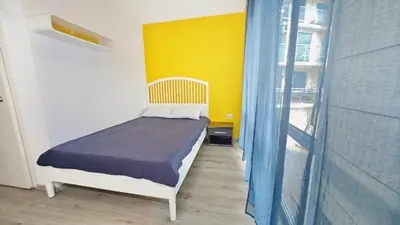a bedroom with a bed and a yellow wall at KJ Apartments - SwimmingPool - 3 Min From the Beach in Burgas City