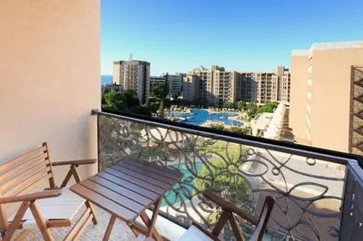 a balcony with a wooden bench and a view of a city at ROYAL BEACH HOTEL apartment SEA G in Sunny Beach