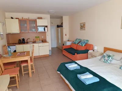 a kitchen and a living room with a bed and a table at Aquamarin Studio B - Słoneczny Brzeg-Nesebyr in Sunny Beach