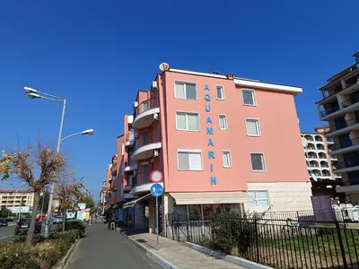a pink building with a sign on the side of it at Aquamarin Studio B - Słoneczny Brzeg-Nesebyr in Sunny Beach
