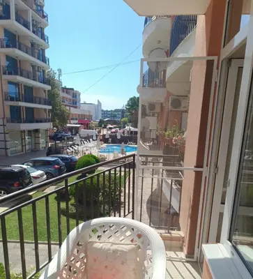 a balcony with a chair and a view of a city at Aquamarin Studio B - Słoneczny Brzeg-Nesebyr in Sunny Beach