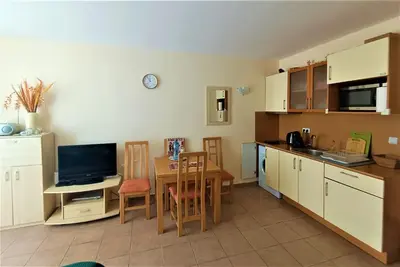 a kitchen with a table and a television and a kitchen with a dining room at Aquamarin Studio B - Słoneczny Brzeg-Nesebyr in Sunny Beach