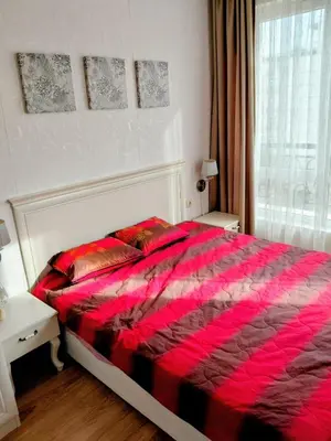 a bedroom with a red bed with two tables and a window at Izida Palace Garden SPA Oasis in Bŭnzareto