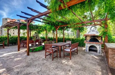 a patio with a table and chairs and a fireplace at Izida Palace Garden SPA Oasis in Bŭnzareto